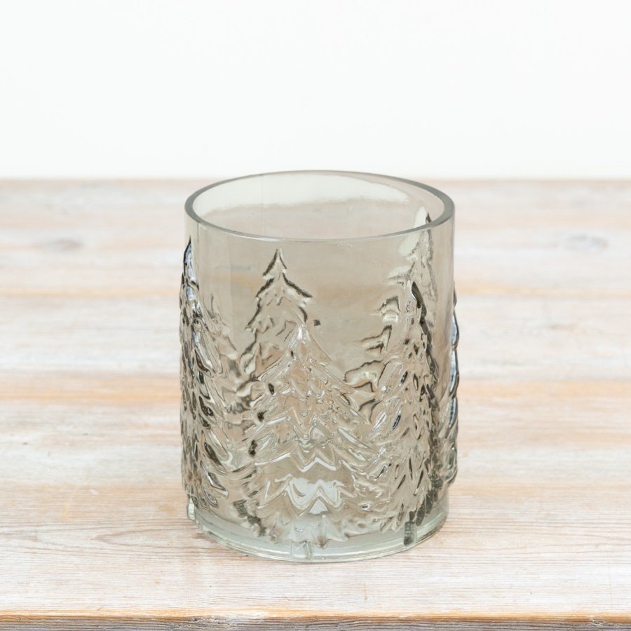 Smokey glass candle holder features beautifully embossed Christmas tree silhouettes around the glass