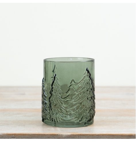 A compact green glass hurricane featuring embossed Christmas trees that beautifully enhance flickering candlelight.