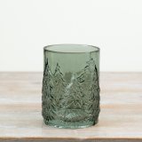 A stylish green glass featuring embossed Christmas trees that beautifully enhance flickering candlelight.