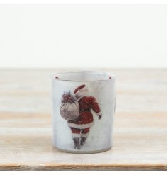 Create a warm festive glow with this charming glass candle holder featuring a classic Santa design. 