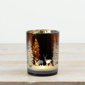  Glass candle holder features an elegant woodland design with deer and trees that softly appear when illuminated. 