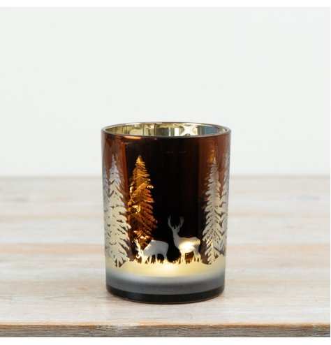 Candle holder featuring a woodland deer and tree design that glows beautifully when a candle is lit