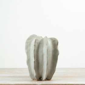 Crafted in stoneware with a softly contoured, free-form shape, this 23cm vase brings an organic, architectural feel