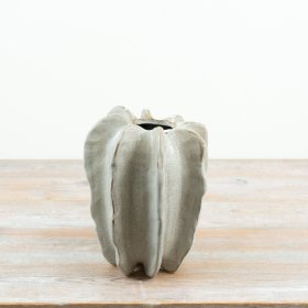 Crafted in stoneware with a softly contoured, free-form shape, this 23cm vase brings an organic, architectural feel