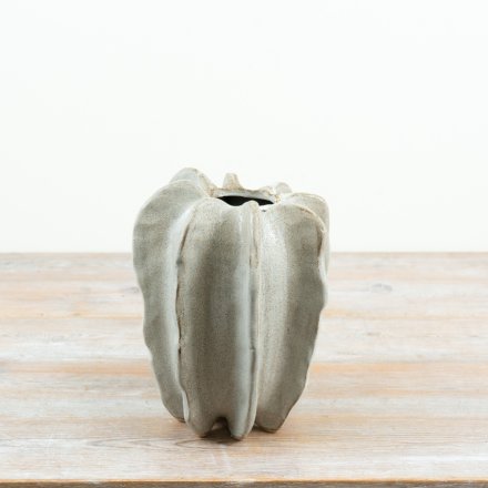 A striking 23cm stoneware vase with a sculptural, organic silhouette and soft neutral finish.