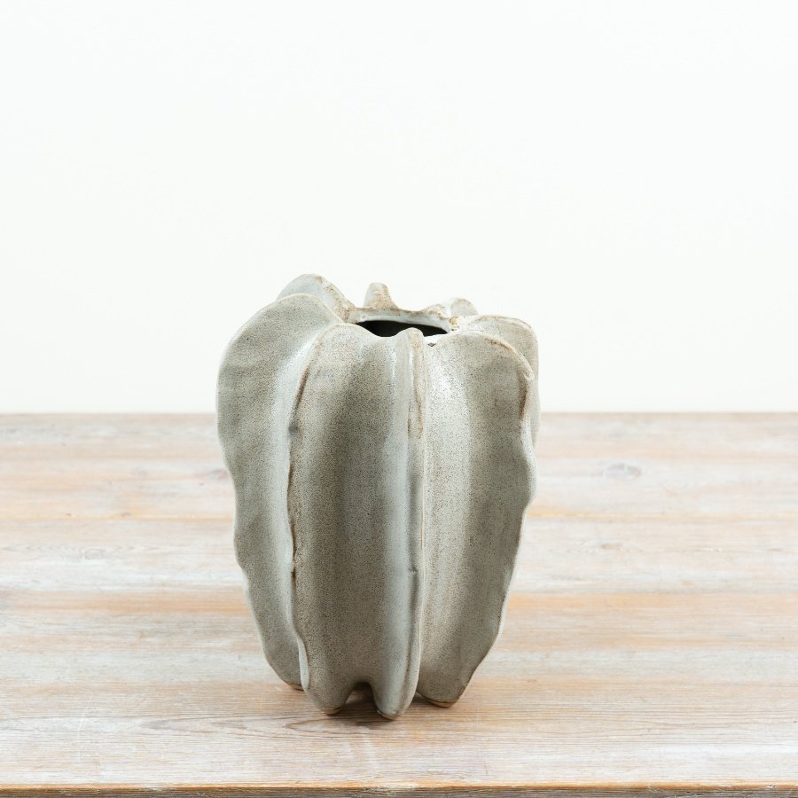 Crafted in stoneware with a softly contoured, free-form shape, this 23cm vase brings an organic, architectural feel