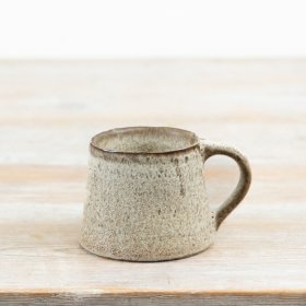 A mug crafted with an earthy toned glaze and subtle textured finish