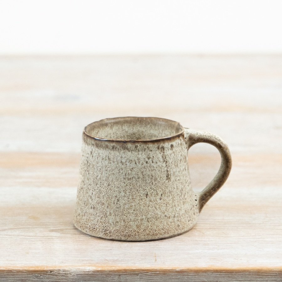 A mug crafted with an earthy toned glaze and subtle textured finish