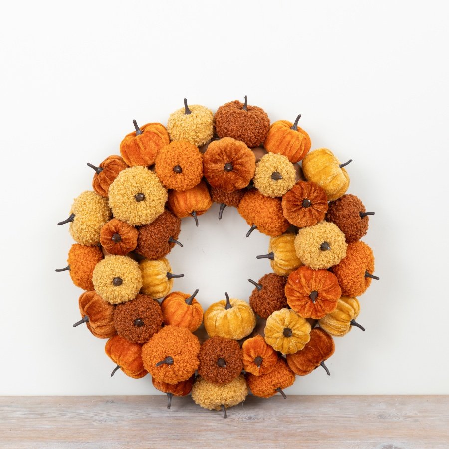 Bring cozy fall vibes home with this charming pumpkin wreath in warm orange, yellow, and brown hues.