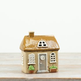 A beautifully detailed ceramic house tealight holder with a warm, rustic finish.