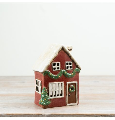 A charming tealight candle house featuring classic red hues and traditional design.