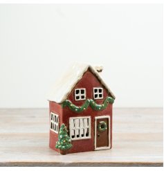 A charming tealight candle house featuring classic red hues and traditional design.