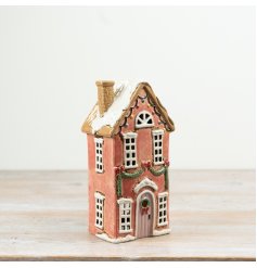 Add cozy charm to your space with this elegant brown ceramic Tall Tlight Candle House