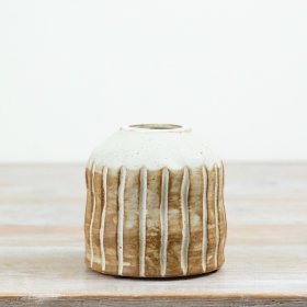Designed with a soft earthy palette, this 10cm ceramic vase features engraved vertical stripes and a beautifully rustic 