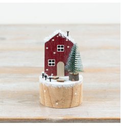 Bring warmth to your collection with this charming wooden winter house ornament.