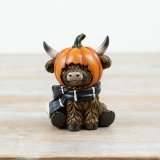 Add a charming touch to your Halloween décor with this sitting Highland cow ornament