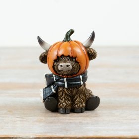 Bring charm to your Halloween décor with this adorable sitting Highland cow ornament.