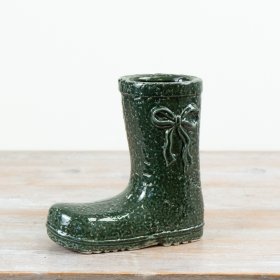 Crafted in ceramic with a glossy green finish, this welly boot vase showcases textured detailing and a raised bow accent