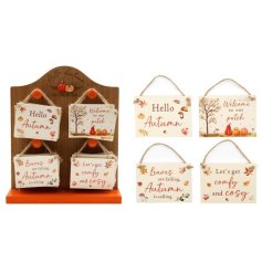 An assortment of autumn themed wooden plaques, each with a beautiful leaf and pumpkin design. 