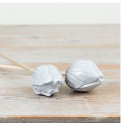 Add a charming touch to any space with this delicate speckled white tulip on a wooden stake