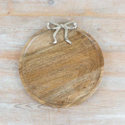 Stylish wooden plate featuring a silver bow accent design.