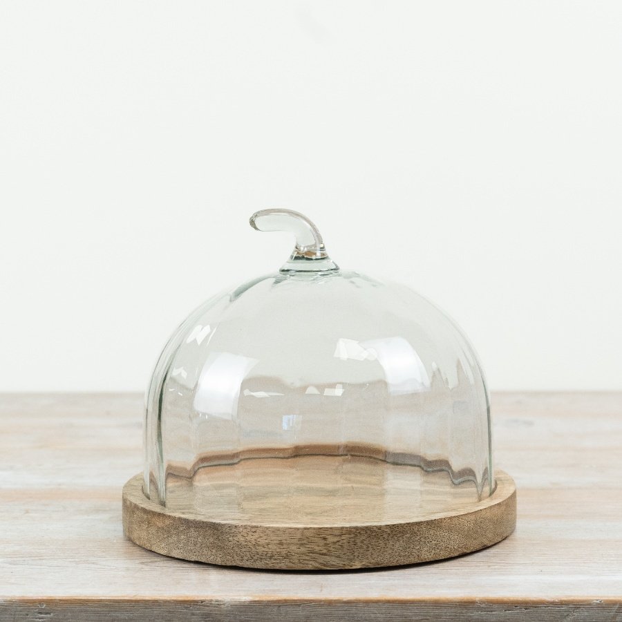 Stylish cake stand featuring a natural wood base and clear glass dome, ideal for displaying your cakes.