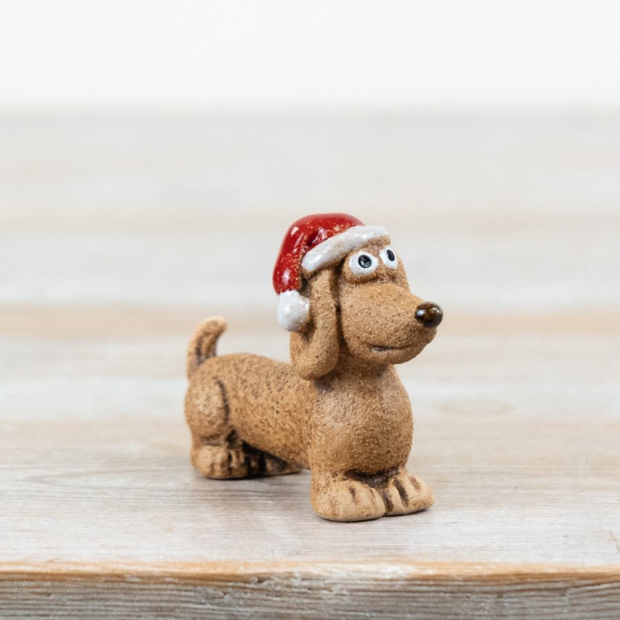 Add a touch of festive charm with this adorable dog decoration, finished in a textured stone-effect and topped with a cl