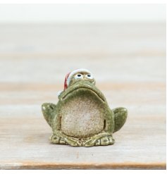 A fun decorative frog ornament wearing a classic Santa hat, finished with a textured stone-effect look.