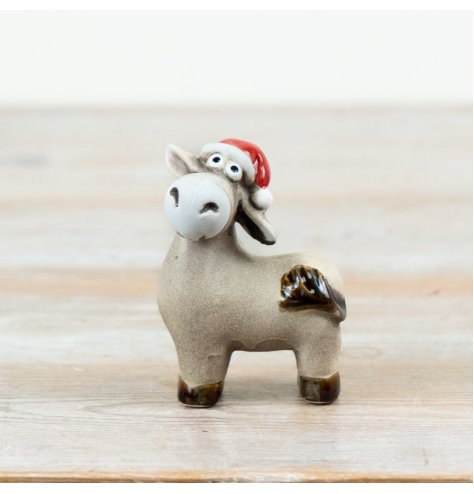 Charming donkey ornament with Santa hat and scarf, in soft neutrals with a gentle glossy finish.
