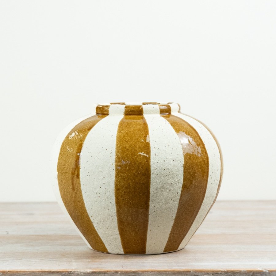 This statement ceramic vase features a rounded silhouette with hand-finished vertical stripes in warm earthy tones. 
