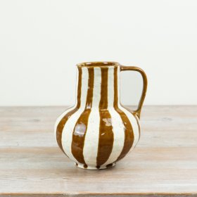 This ceramic jug-style vase features a softly rounded silhouette with an integrated handle and a hand-finished stripe