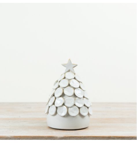 This decorative ceramic tree showcases textured layered detailing in a glossy white finish, complete with a star