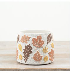 Decorative cement planter features a raised autumn leaf design in cosy, earthy tones.