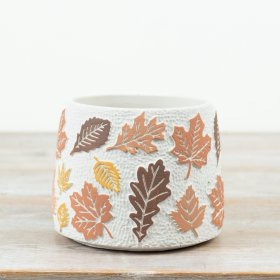 Textured cement planter with raised leaf detailing in warm, earthy tones.