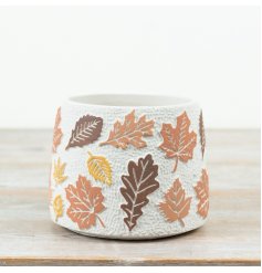 Textured cement planter with raised leaf patterns in rich autumn hues.