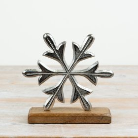 A striking aluminium snowflake sculpture set on a solid mango wood base