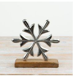 A decorative aluminium snowflake ornament mounted on a mango wood base