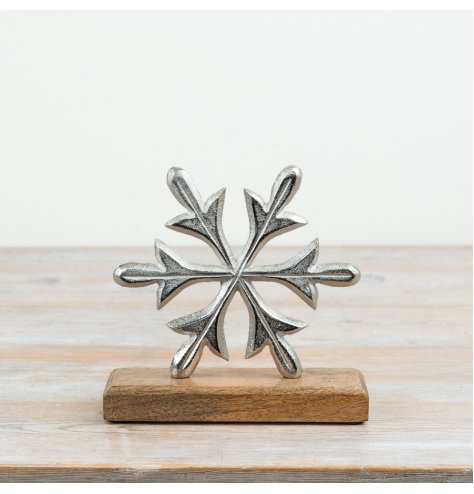 A festive aluminium snowflake decoration mounted on a natural mango wood base