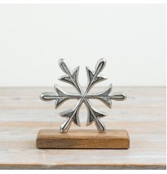 A decorative aluminium snowflake ornament mounted on a mango wood base.