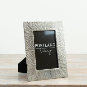 A striking photo frame with a textured metallic effect surround and clean black inner mount.