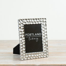 A bold photo frame featuring a pebble-textured metallic surround with a luxe