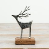A festive aluminium reindeer decoration mounted on a natural mango wood base.