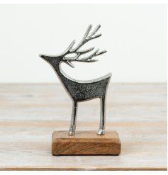 A decorative aluminium reindeer ornament mounted on a mango wood base.