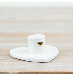 This porcelain candle holder features a clean white finish, a heart-shaped base, and a small gold heart detail at the st