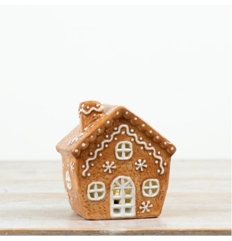 A delightful light-up gingerbread house featuring detailed white icing decoration and warm LED illumination