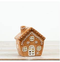 Gingerbread house features charming icing-style detailing and a warm internal glow for a cosy festive finish. 