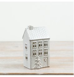 Ceramic decorative house finished in a natural glaze with window cut-outs and a 3D Christmas tree detail.