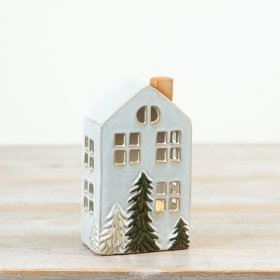Crafted in a tall townhouse design, this decorative piece features delicate cut-out windows and hand-finished fir tree 