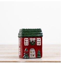 A delightful candle house in festive red and green colors.
