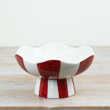 Crafted from ceramic with a high-gloss finish, the piece is elevated on a coordinating pedestal base